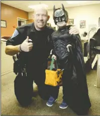  ?? Submitted photo ?? HELPING BATMAN: Officer 1st Class Joey Williams, left, kneels next to Jaxton Yerby, 6, at the Hot Springs Police Department on Nov. 1. Williams organized a special trick-or-treat opportunit­y for Yerby after he missed Halloween due to illness.