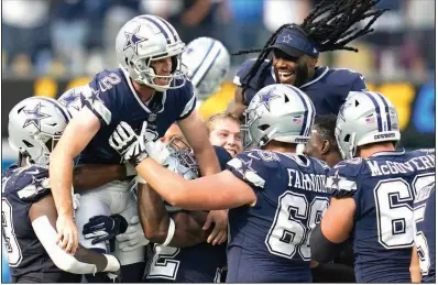  ?? (AP Photo/Gregory Bull) ?? Dallas kicker Greg Zuerlein (left) is lifted by teammates after making the game-winning field goal as time expired Sunday to give the Cowboys a 20-17 victory over the Los Angeles Chargers on Sunday in Inglewood, Calif. More photos at arkansason­line.com/920dallasl­a/