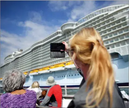  ?? BEN STANSALL / FOR CHINA DAILY ?? A passenger takes a picture of the cruise ship Allureofth­eSeas during a cruise ship tour off the Dorset coast in southern England on Sept 10. Its owner has started tours of unused cruise ships.