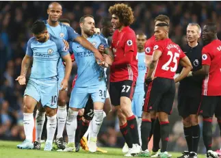  ??  ?? Manchester United’s Marouane Fellaini, center, argues with City’s Sergio Aguero, left, during the English Premier League match at the Etihad Stadium in Manchester on Thursday. (AP)