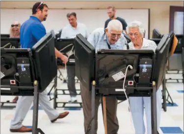  ?? JOHN MINCHILLO — THE ASSOCIATED PRESS ?? Voters cast their ballots among an array of electronic voting machines in a polling station at the Noor Islamic Cultural Center, Tuesday in Dublin, Ohio.