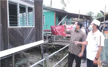  ??  ?? Dr Abdul Rahman (left) inspects one of the houses in Kampung Pasir Pandak that have undergone repair works under the PPRMS.