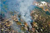  ?? AP ?? WIldfires in Mideast: In this frame grab from video, a helicopter drops water on a forest fire in Ras el-Harf village, in the Baabda district of Lebanon on Friday. Wildfires around the Middle East triggered by a heatwave have killed two people, forced thousands to leave their homes and detonated landmines along the Lebanon-Israel border.