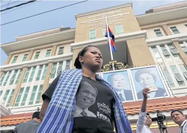  ?? REUTERS ?? A supporter of anti-government figure Kem Ley waits outside the court building in Phnom Penh during the trial of Chuop Somlap, who is charged with murdering Kem Ley.