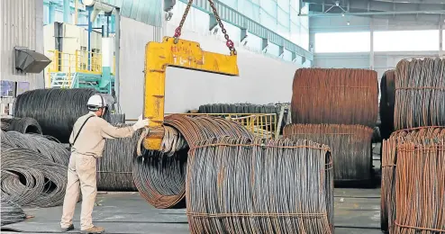  ??  ?? BIG SHOWDOWN: Employees transfer coils of steel wire at a steel factory in Nantong, China. Steep American tariffs on Chinese goods worth billions of dollars are due to take effect today