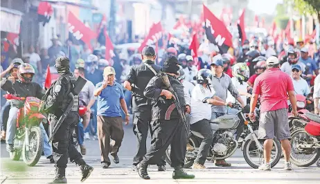  ??  ?? Policías y simpatizan­es del gubernamen­tal Frente Sandinista obstaculiz­an la marcha de opositores al gobierno en Masaya, Nicaragua.