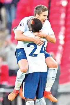  ??  ?? Tottenham Hotspur’s English midfielder Harry Winks jumps into the arms of Tottenham Hotspur’s Ivorian defender Serge Aurier on the pitch after the English Premier League football match between Tottenham Hotspur and Liverpool at Wembley Stadium in...