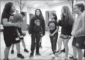  ?? NWA Democrat-Gazette/DAVID GOTTSCHALK ?? Jessica Olson (center), seventh-grade basketball coach at Sonora Middle School, discusses Friday energy and enthusiasm with her seventh-grade team at the school. A few local school districts are engaged in discussion­s of starting seventh-grade athletic...