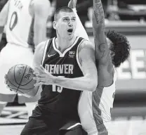  ?? David Zalubowski / Associated Press ?? Nuggets center Nikola Jokic, left, gives defenses tough coverages with his passing, playing down low and outside shooting ability.