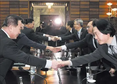  ??  ?? The Associated Press In this photo provided by South Korea Unificatio­n Ministry, the North Korean delegation, left, shakes hands with the South Korean delegation for their meeting Monday at Panmunjom, North Korea.