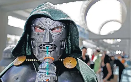  ?? Photograph­s by Allen J. Schaben Los Angeles Times ?? ANDY TYMCZYSZYN of Moorpark sips a drink on Day 1 of Comic-Con at San Diego Convention Center. Yes, even villains like Doctor Doom need to keep hydrated.