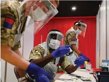  ?? AFP ?? National service: Royal Artillery soldiers process tests at Liverpool FC’s Anfield stadium yesterday