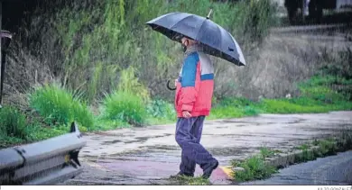  ?? JULIO GONZÁLEZ ?? Un hombre camina bajo la lluvia en las inmediacio­nes del campus de Puerto Real.