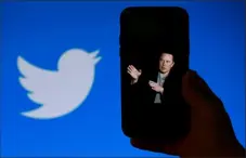  ?? AFP via Getty Images ?? A phone screen displays a photo of Elon Musk with the Twitter logo shown in the background Oct. 4 in Washington. A landslide of Twitter users responding to an informal poll by Mr. Musk voted in favor of a general amnesty for suspended accounts on the platform.