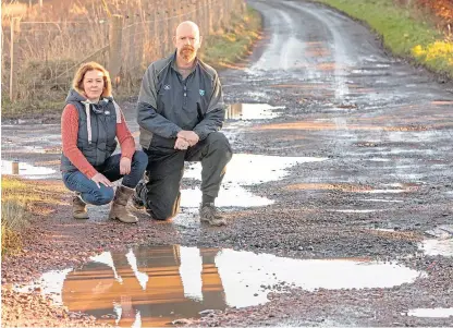  ?? Picture: Steven Brown. ?? Laura Mysak and Alastair Stewart, residents of Rameldry near Kingskettl­e, are looking for help from Fife Council to repair the potholed road.