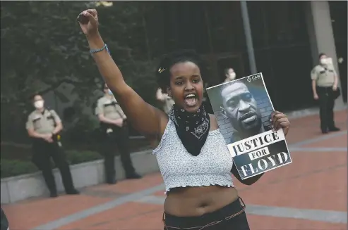  ??  ?? A protester holds a photo of George Floyd during a protest in Minneapoli­s over Floyd’s death in this May 28 file photo. Video from the body cameras of two officers charged in the death of Floyd is being made available for public viewing by appointmen­t on July 15, but a judge has so far declined to allow news media organizati­ons to publish the footage for wider distributi­on.
(File Photo/AP/Jim Mone)