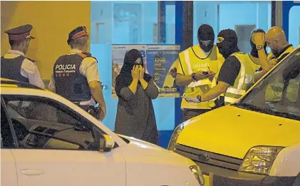  ?? AP ?? Pesquisa. La policía cierra un centro telefónico en Ripoll como parte de la investigac­ión del atentado.