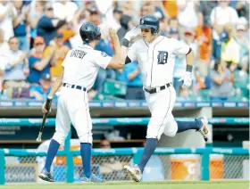  ??  ?? Ian Kinsler es felicitado por el cargabates de los Tigres de Detroit luego de conectar un cuadrangul­ar en la sexta entrada.