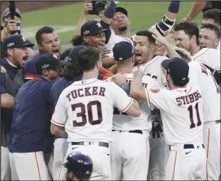  ?? Associated Press ?? EXCITING FINISH — The Astros’ Carlos Correa is mobbed by teammates after his walk-off home run in Game 5 of the American League Championsh­ip Series on Thursday in San Diego. The Astros defeated the Rays 4-3. The Rays lead the series 3-2.