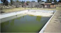  ??  ?? NO MORE SWIMMING: Stagnant water fills the pool which was once enjoyed by those at the base