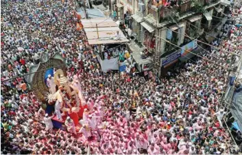  ?? Reuters ?? Devotees carry the idol of Ganesh, the deity of prosperity, during a procession on the last day of the Ganesh Chaturthi festival, before immersing the idol into the Arabian sea, in Mumbai, on Tuesday.—