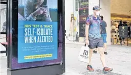 ?? GLYN KIRK/GETTY-AFP ?? A shopper walks past an advertisme­nt for the UK government’s NHS Test and Trace system in Regent Street in London on Monday as some non-essential retailers reopen.