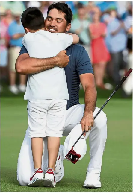  ?? — AFP ?? Dashing Daddy: Jason Day of Australia celebrates with his son Dash on the 18th green after winning the 2018 Wells Fargo Championsh­ip at Quail Hollow Club in Charlotte, North Carolina on Sunday.