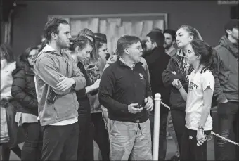  ?? PHOTO COURTESY OF CONNECTICU­T COLLEGE ATHLETICS ?? Connecticu­t College women’s indoor track and field coach Ned Bishop, center, talks with two of his athletes during a meet this season. Bishop was in North Carolina for the NCAA Division III Championsh­ips when the meet was canceled due to the coronaviru­s pandemic.