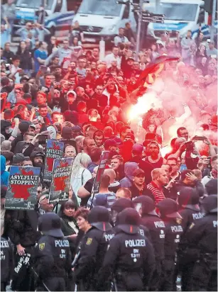  ?? ODD ANDERSEN AFP,GETTY IMAGES ?? Right-wing demonstrat­ors light flares Monday in Chemnitz amid a series of violent protests.