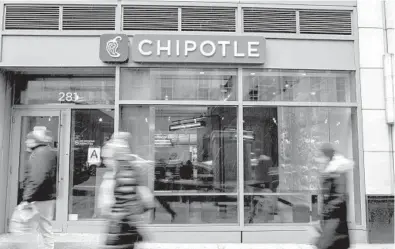  ?? ANDREW RENNEISEN/GETTY 2016 ?? People walk by a Chipotle restaurant in New York City. The fast-food chain cited higher labor costs for a 4% hike in the price of its menu items last summer and is looking for other ways to boost profitabil­ity. That includes higher prices for delivery.