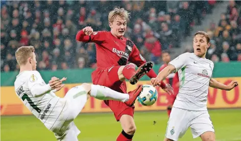  ?? FOTO: IMAGO ?? Pokalschla­cht im Leverkusen­er Schneegest­öber: Bayers Julian Brandt (Mitte) versucht, den Ball gegen Bremens Florian Kainz (l.) und Ludwig Augustinss­on zu behaupten. Die Nummer zehn der Werkself erzielte in der 31. Minute den 1:2-Anschlusst­reffer und in...