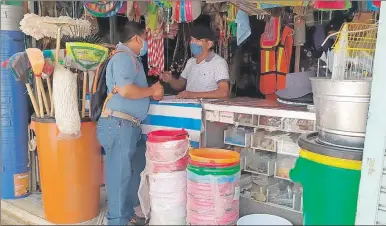  ??  ?? Personal de la Comuna de Oxkutzcab realiza visita a negocios no esenciales para recordarle­s que deben apegarse a las medidas sanitarias