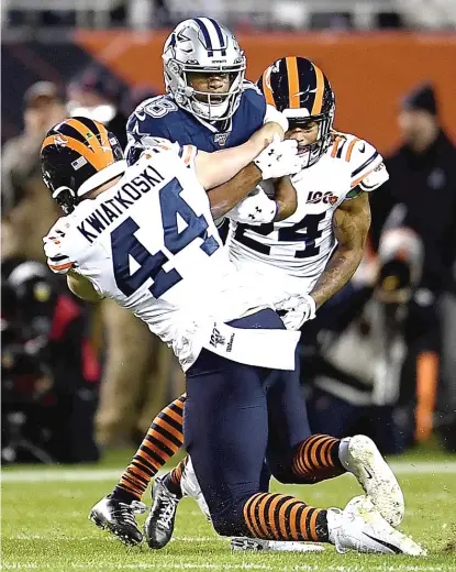  ?? STACY REVERE/GETTY IMAGES ?? The Bears’ Nick Kwiatkoski and Buster Skrine combine to bring down Cowboys receiver Randall Cobb.