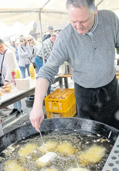  ?? Fotos: Klaus Frensing ?? John Mason nimmt den Backfisch erst wieder aus dem siedenden Öl heraus, wenn er goldgelb frittiert ist.