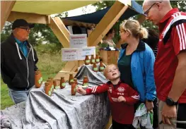  ??  ?? PÅ KORV. Roger Nilsson från Varberg säljer egentillve­rkad senap till familjen Rylin: Charlie, Ulrika och Anders.