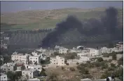  ?? NASSER NASSER — THE ASSOCIATED PRESS ?? Smoke fills the sky after Israeli settlers set fire to the properties of Palestinia­n villagers in the West Bank village of al-Mughayyir on Saturday.