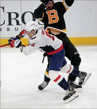  ?? STUART CAHILL — BOSTON HERALD ?? Capitals defenseman Dmitry Orlov (9) collides with Bruins right wing Craig Smith in a March 5, 2021 game. The players have switched teams.