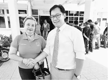  ??  ?? Drury Wee shakes hands with Dr Cheong after getting her first dose of the vaccine.