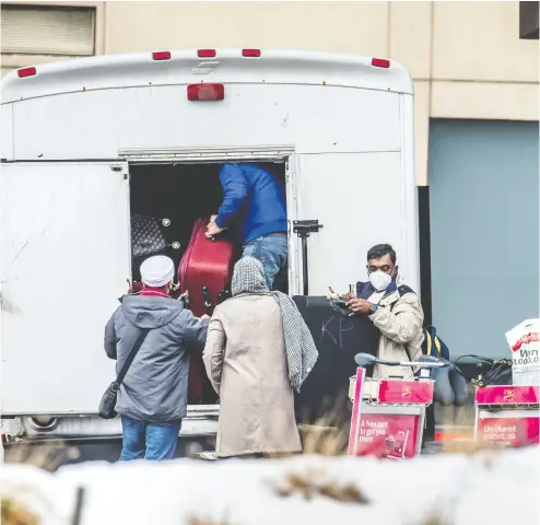  ?? PETER J THOMPSON / POSTMEDIA NEWS ?? Travellers arrive at a mandatory quarantine hotel on Monday after flying into Toronto’s Pearson Airport.