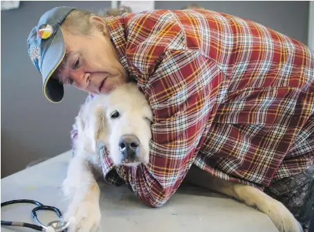  ?? THE CANADIAN PRESS PHOTOS ?? Mark Matthews comforts his dog, Bounder, who has lymphocyti­c leukemia, at a free animal health-care clinic in Vancouver’s Downtown Eastside. Bounder saw Matthews through a period of homelessne­ss.