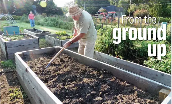  ??  ?? Soil in a raised bed should be refreshed after each growing season; compost and other amendments can be mixed in before planting. Master Gardener Susan Buckner approaches as deceased Master Gardener Mike Badovick prepares soil for planting in a raised bed in this 2014 file photo.