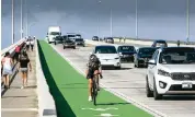  ?? JOSE A. IGLESIAS jiglesias@elnuevoher­ald.com ?? A cyclist in the bike lane travels along the William Powell Bridge between Miami and Key Biscayne.