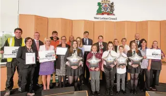  ??  ?? Celebratio­n Council staff and school pupils with leader of West Lothian Council John McGinty and chief executive Graham Hope