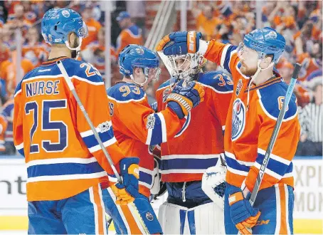  ?? CODIE McLACHLAN/GETTY IMAGES ?? Oilers defencemen, left, Darnell Nurse and Adam Larsson, right, celebrate with centre Ryan Nugent-Hopkins and goalie Cam Talbot after their 7-1 victory over the Anaheim Ducks in Game 6 on Sunday in Edmonton. The Ducks host the Oilers for Game 7 on...