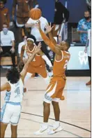  ??  ?? Matt Coleman III of Texas shoots for the winning basket over North Carolina’s RJ Davis.