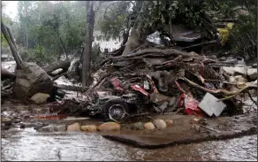  ?? Daniel Dreifuss ?? Mudslides: A car and debris smashed against a tree along Hot Springs Road in Montecito, Calif. Heavy rain brought flash flooding and mudslides to the area in Montecito, Calif. on Tuesday. At least five people were killed and homes were swept from their...