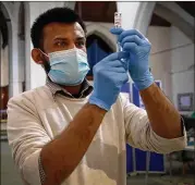  ?? KIRSTY WIGGLESWOR­TH/ ASSOCIATED PRESS ?? Pharmacist Rajan Shah preps an Astrazenec­a vaccine Tuesday in London. In recent days, some countries suspended use of Astrazenec­a’s vaccine after reports some recipients got blood clots.