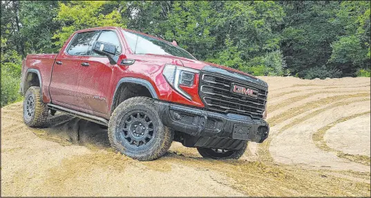  ?? Henry Payne The Detroit News ?? With front and rear lockers, 460-torque and 11-inches of ground clearance, the 2023 GMC Sierra AT4X AEV Edition likes to be thrown around in the sand. As a GM product, the GMC also benefits from industry-leading ergonomics.