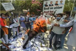  ?? — PTI ?? BJP activists burn an effigy of Delhi CM Arvind Kejriwal along with electricit­y bills during a protest against AAP over power bills in New Delhi on Monday.