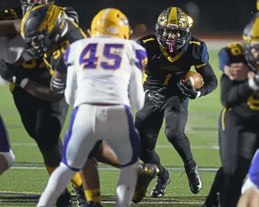  ?? Alexandra Wimley/Post-Gazette ?? Farrell running back Christian Lewis (1) attempts to get through Our Lady of the Sacred Heart’s defense during the PIAA Class 1A semifinals Friday night at Slippery Rock University.